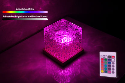 Ocean wave projector on a  glass top nightstand, light is reflecting off the glass top of the nightstand in a bright but soothing magenta color.